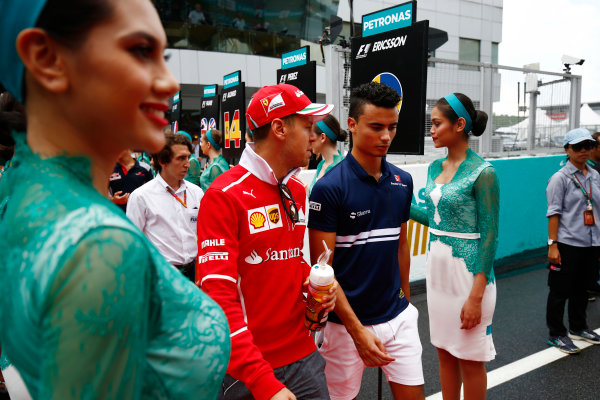 Sepang International Circuit, Sepang, Malaysia.
Sunday 01 October 2017.
Sebastian Vettel, Ferrari, and Pascal Wehrlein, Sauber, walks through a corridor of grid girls.
World Copyright: Andy Hone/LAT Images 
ref: Digital Image _ONY4456