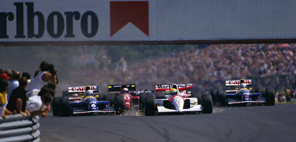 Ayrton Senna, McLaren MP4-6 Honda, with sparks flying as he brakes, leads Riccardo Patrese, Williams FW14 Renault, Alain Prost, Ferrari 643, and Nigel Mansell, Williams FW14 Renault, into the first corner at the start. Ayrton Senna, McLaren MP4-6 Honda, with sparks flying as he brakes, leads Riccardo Patrese, Williams FW14 Renault, Alain Prost, Ferrari 643, and Nigel Mansell, Williams FW14 Renault, into the first corner at the start.