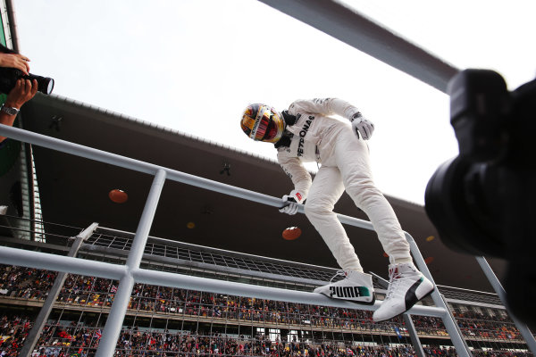 Shanghai International Circuit, Shanghai, China.  Saturday 08 April 2017. 
Lewis Hamilton, Mercedes AMG, celebrates taking pole position by scaling a fence and interacting with fans.
World Copyright: Charles Coates/LAT Images 
ref: Digital Image AN7T9025