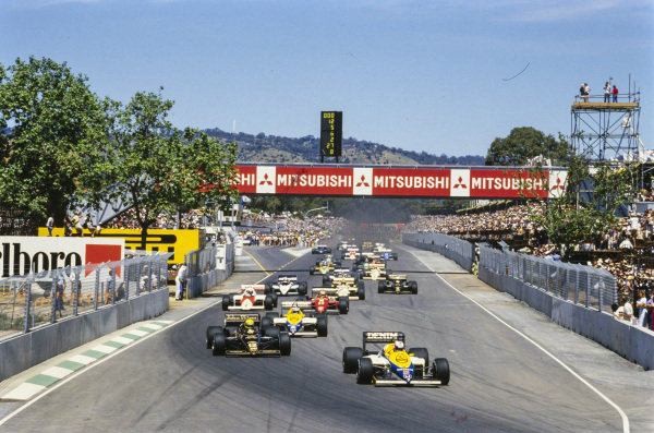 Nigel Mansell, Williams FW10 Honda, leads Ayrton Senna, Lotus 97T Renault, and Keke Rosberg, Williams FW10 Honda, on the run to the first corner. Nigel Mansell, Williams FW10 Honda, leads Ayrton Senna, Lotus 97T Renault, and Keke Rosberg, Williams FW10 Honda, on the run to the first corner.